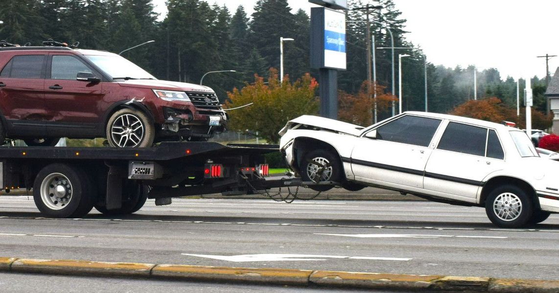 A tow truck towing a car on a flatbed